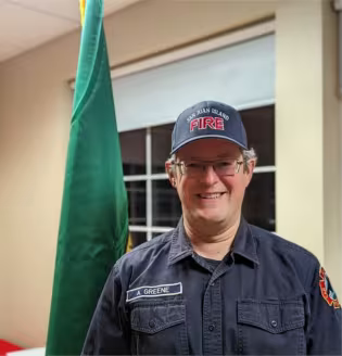 Adam Greene in a San Juan Island Fire cap at the station